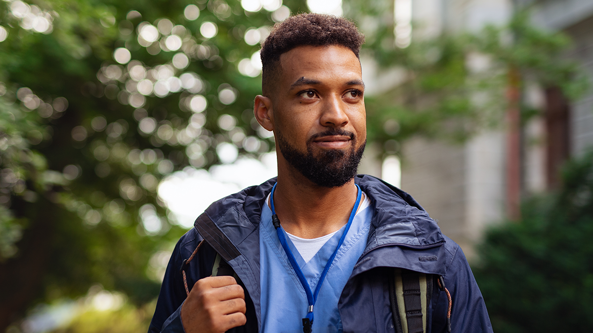 Campaign Insights 1 Portrait of African American male nurse in scrubs outdoors.