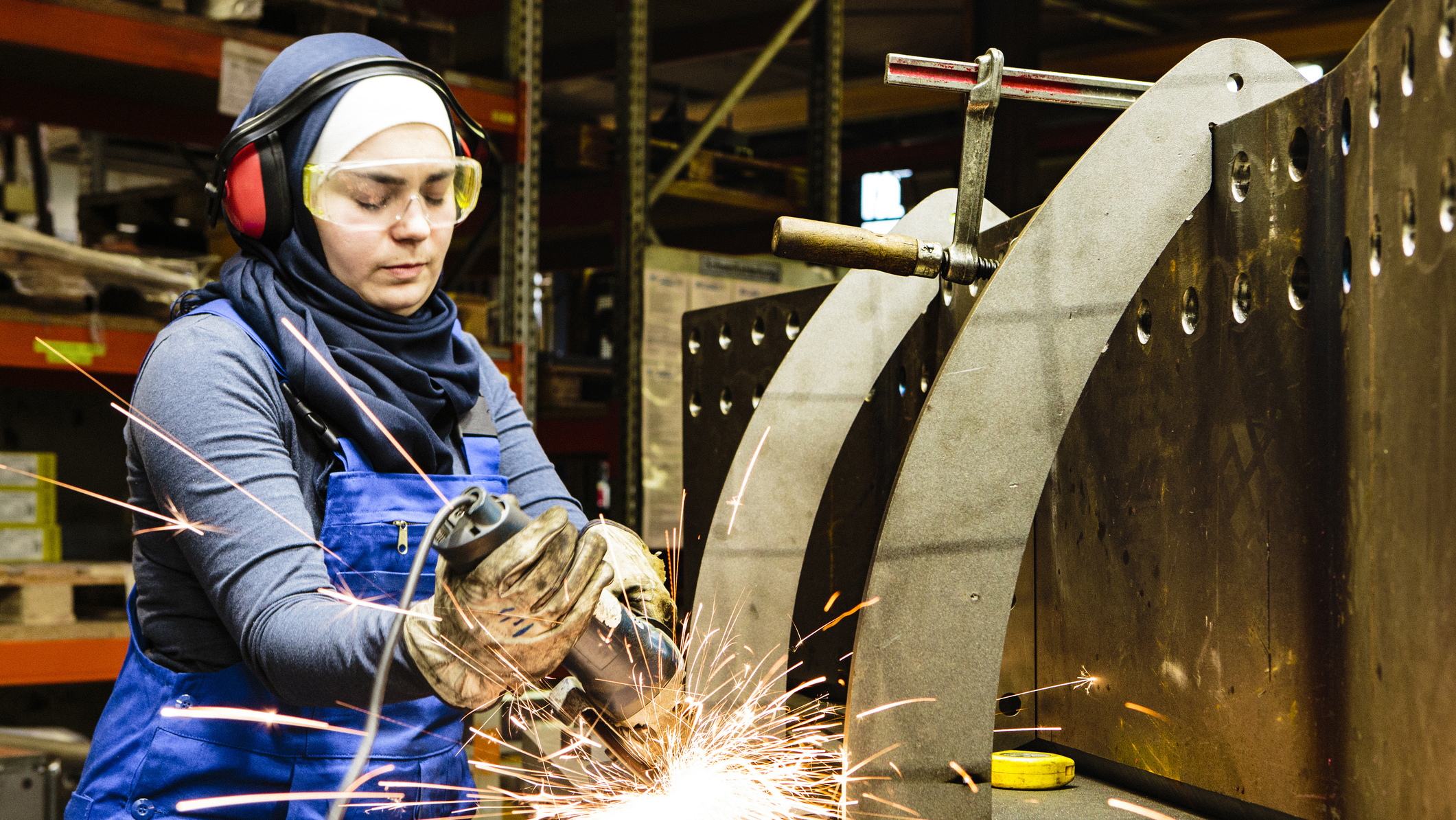 1051092562 A female worker in PPE is shown working in an industrial setting.