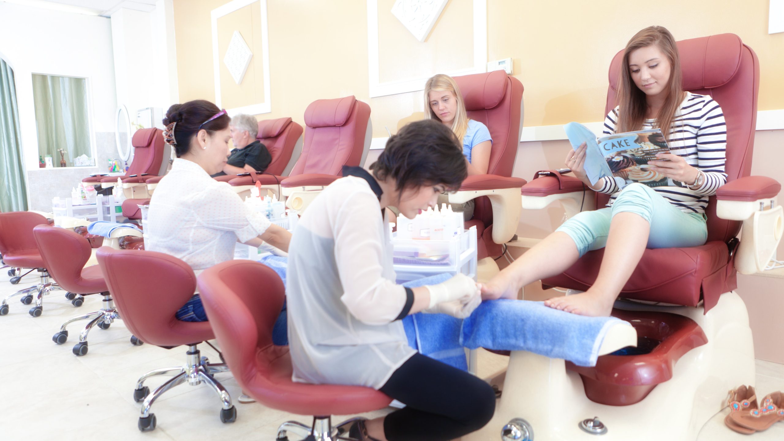 Nail Technician Pedicure Two Asian nail technicians performing pedicures
