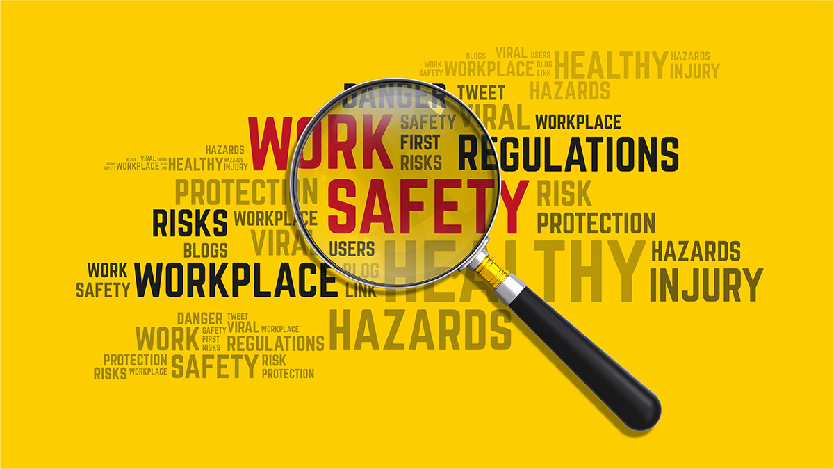 Work Safety Concept word cloud with magnifying glass highlighting work safety in red font and a yellow background.