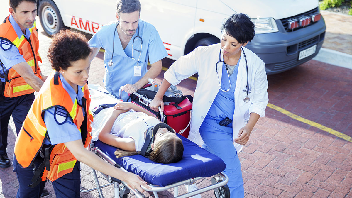 Work Practices and Training page Doctor, nurse and paramedics wheeling patient on stretcher