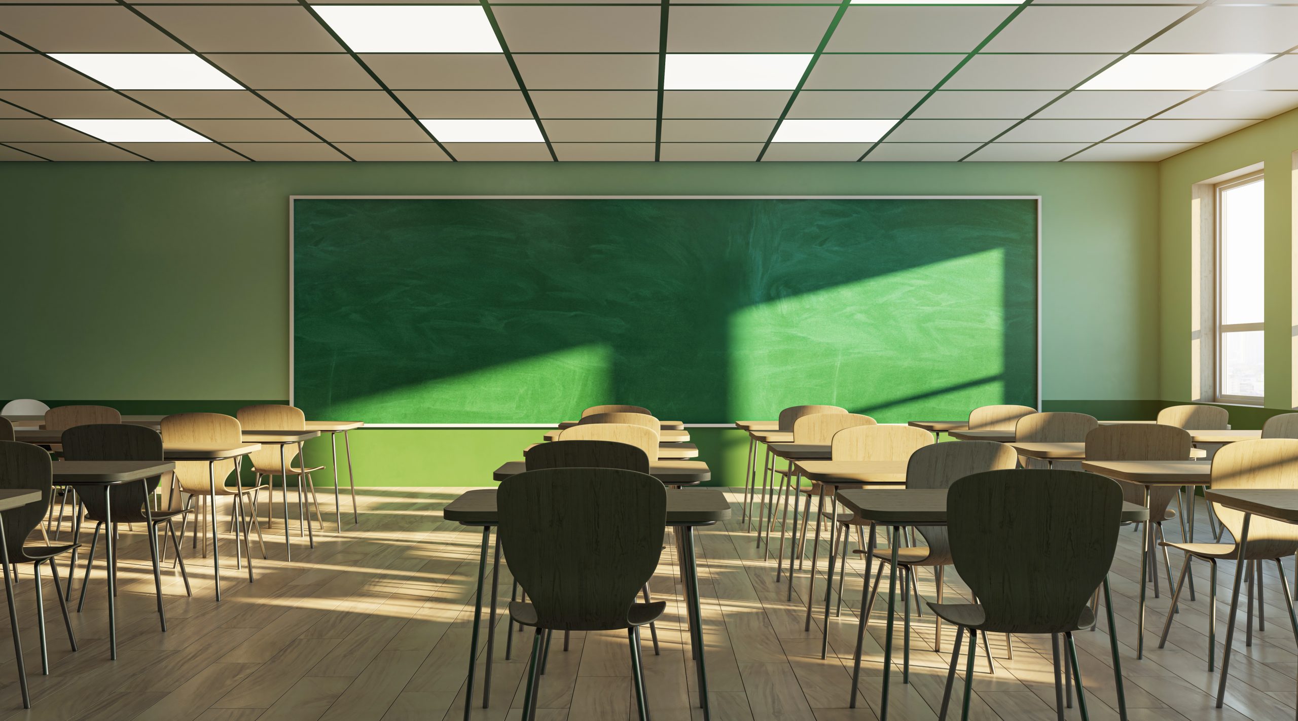 Classroom Desks in an empty classroom in front of a chalkboard.