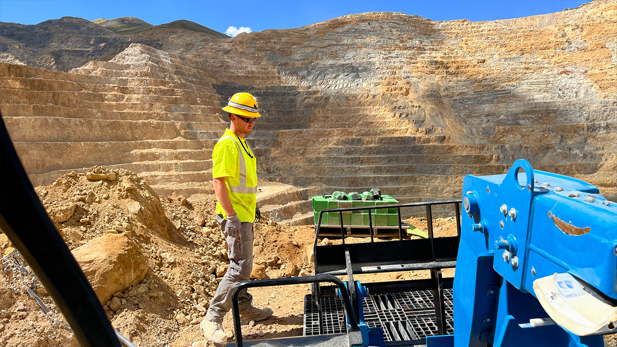 SMRDImage Image of white man, wearing a hard had, working in an open pit mine.