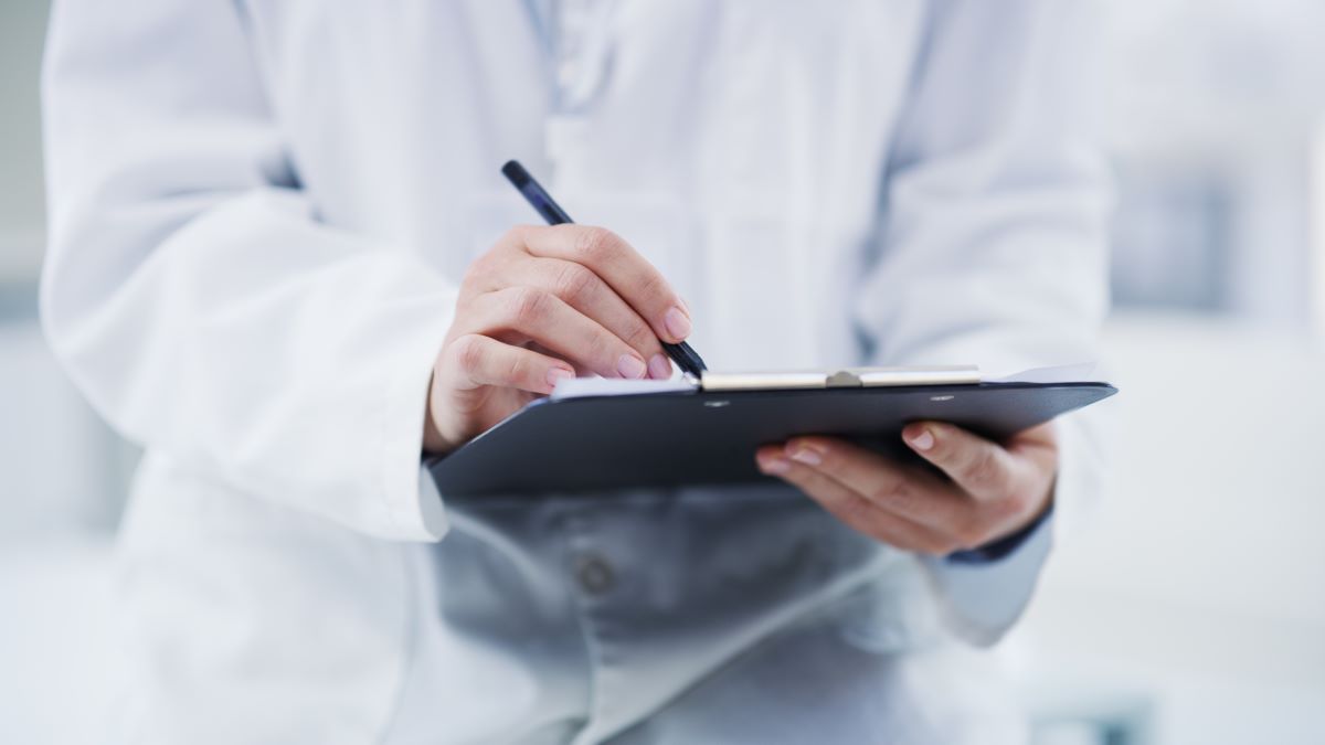 Scientist in lab writing on clipboard