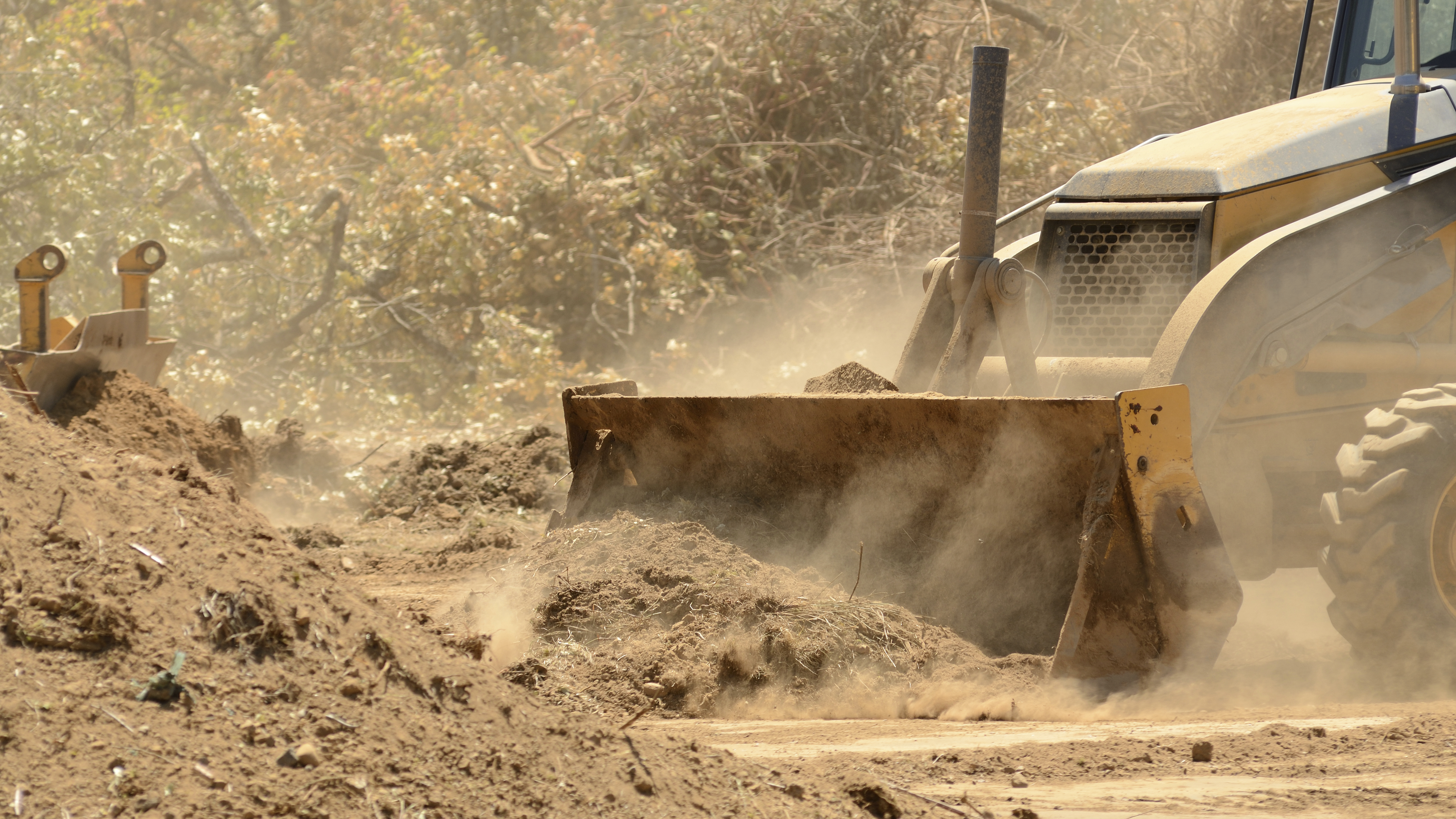 — title missing — Bulldozer pushing dirt with dust.