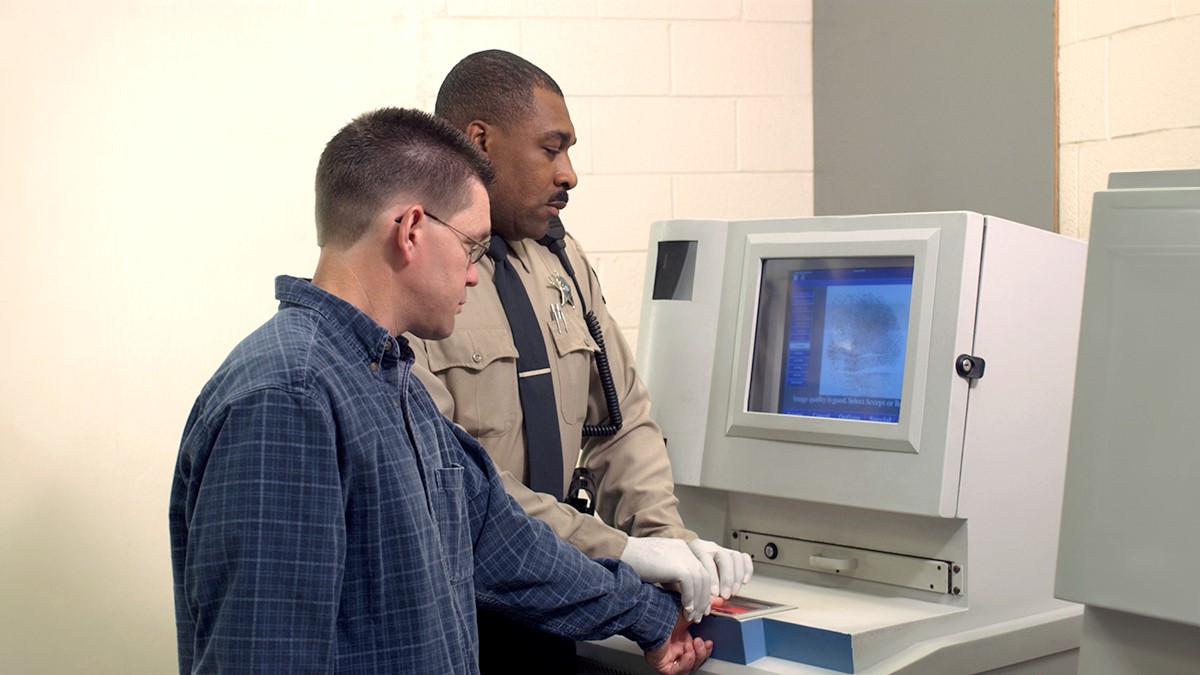 Correctional Officer taking fingerprints Correctional officer taking fingerprints of a detained person.