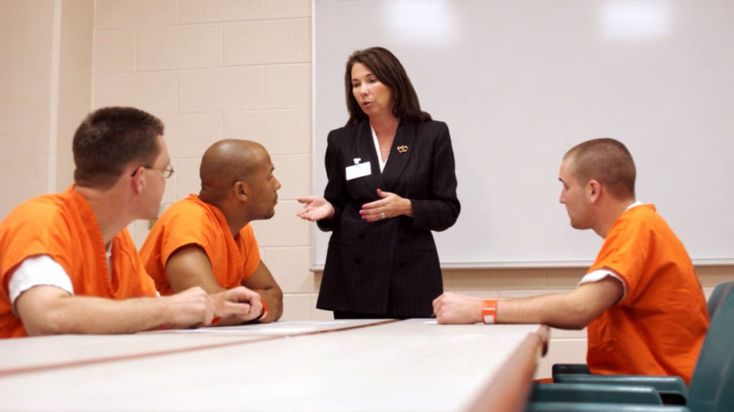 Correctional Worker Correctional worker speaking to three people who are incarcerated.