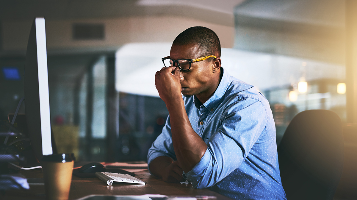 Young African American businessman experiencing stress during work
