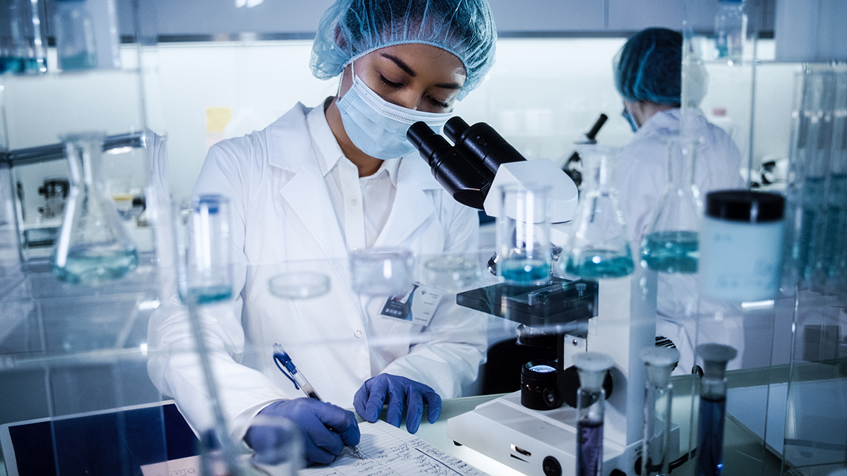 Female researcher Female researcher in a laboratory wearing PPE.
