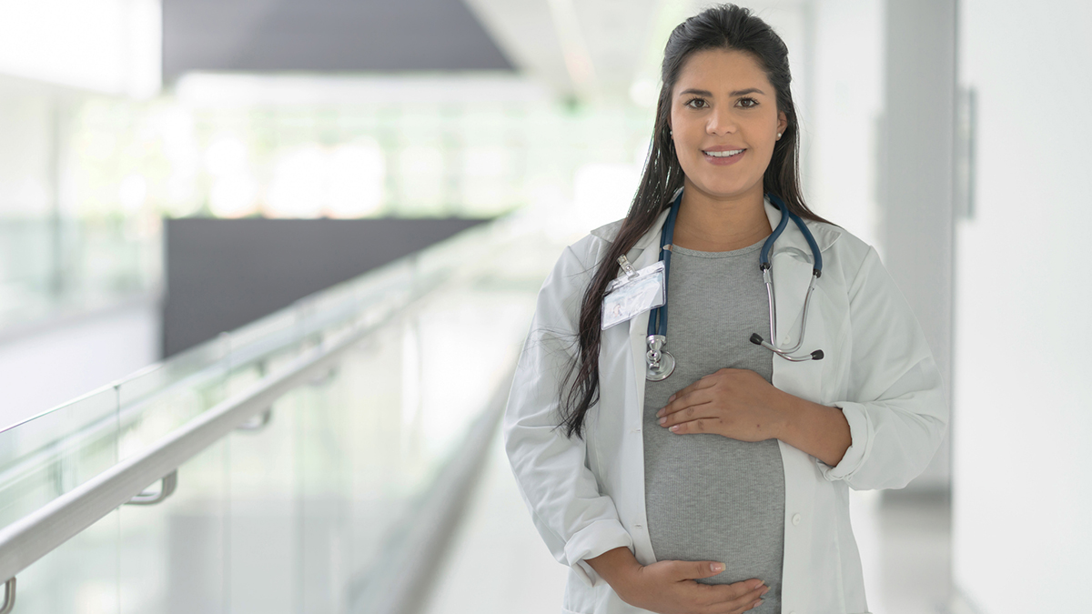 — title missing — Pregnant healthcare worker wearing a stethoscope.