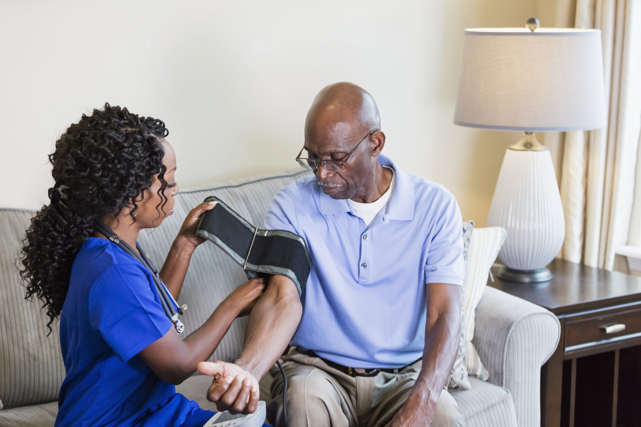 -- title missing -- home nurse checking a senior man's blood pressure.