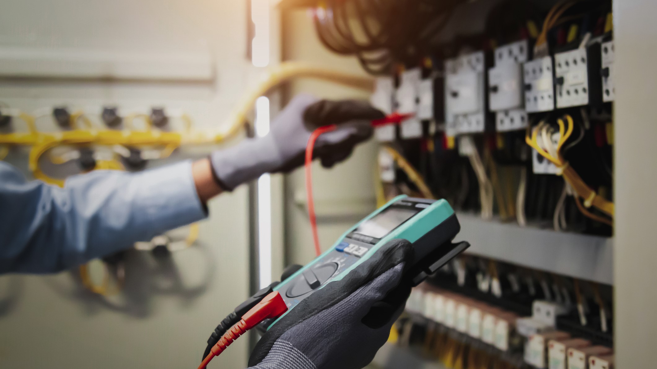 — title missing — A person using a voltage tester to verify electrical power.