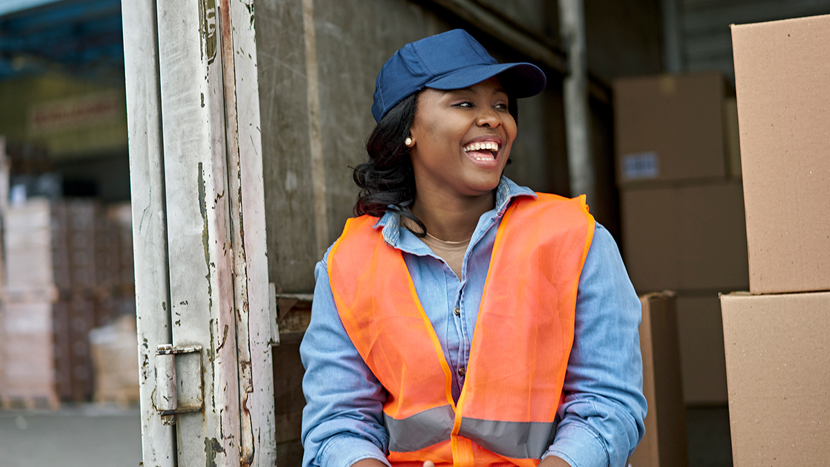 Woman delivering packages sitting in back of truck with boxes