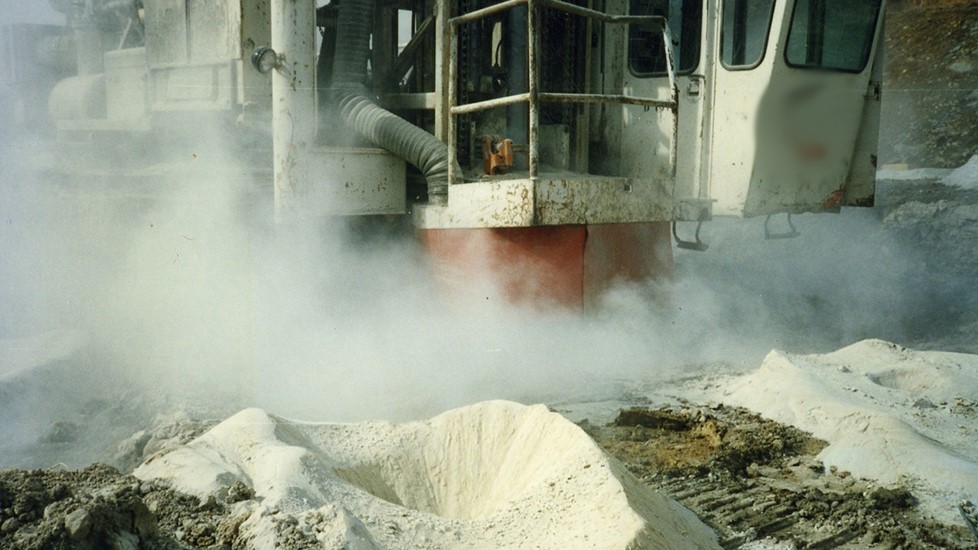 — title missing — A dusty surface mining drill operation where dust control is not being implemented.