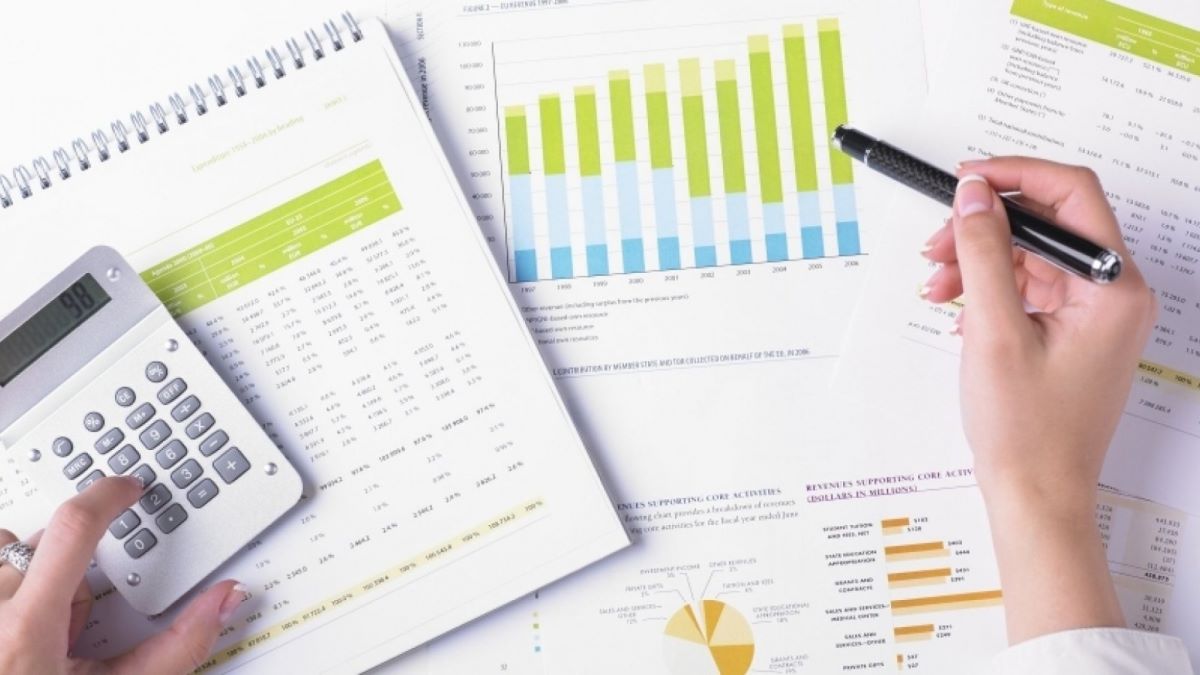performancegraphsthumbnail.jpg Hands over printed graphs and tables, using a calculator.