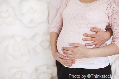 M3L A pregnant woman places her hands on her belly