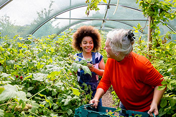 Experts and the community can work together to support One Health. A woman and a girl interact in a garden.