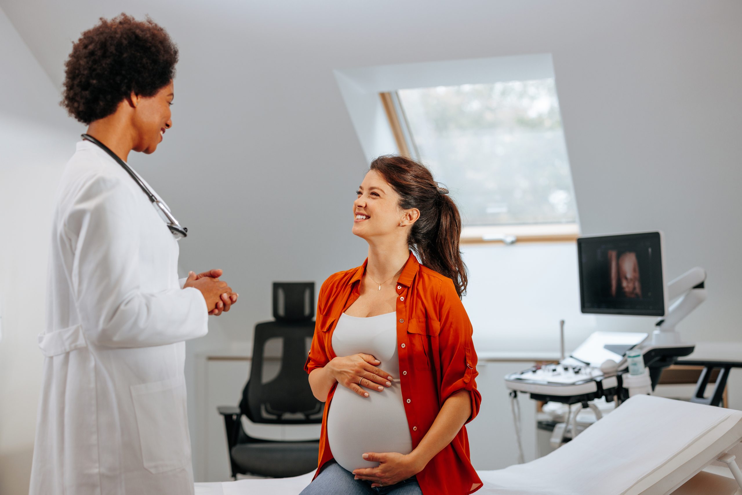iStock1440040666.jpg A pregnant woman talking to her female health care provider.
