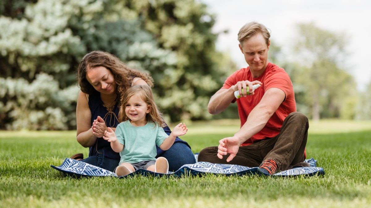 Family using repellent Family on a picnic and using insect repellent to protect themselves from bug bites.
