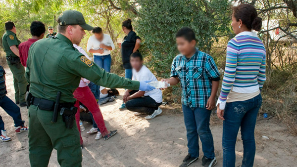 respiratory-disease-2014 Officer providing a water bottle to child.