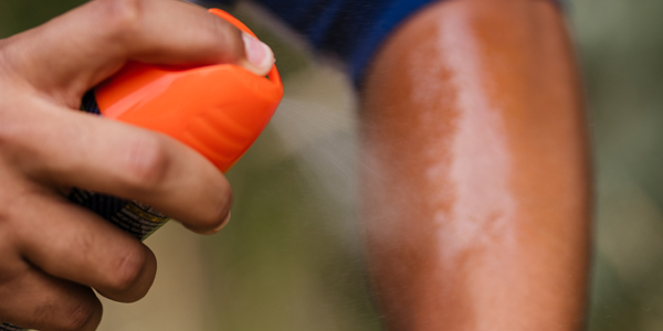 RepellentArm600x300 Person spraying insect repellent onto their arm