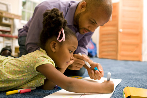 Padre e hija en el piso de color