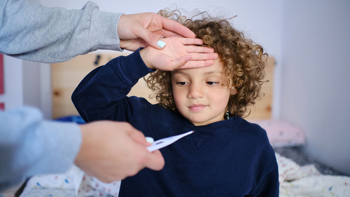 Mom takes temperature. Mother takes the temperature of her child with fever symptoms