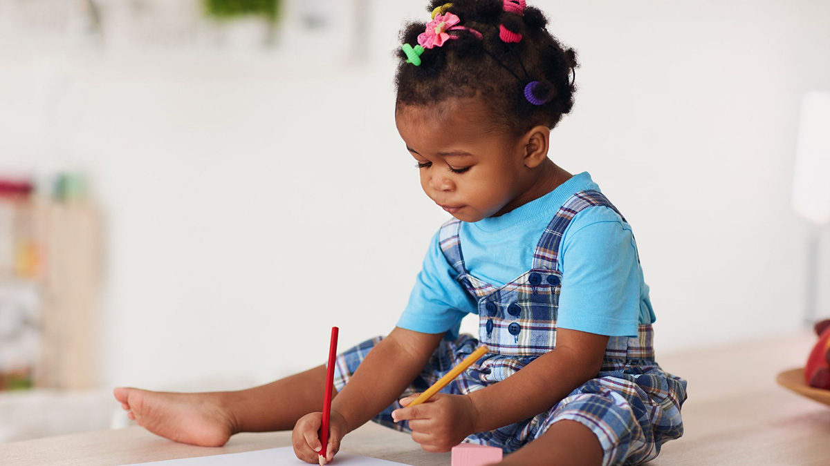 Toddler drawing Cute toddler baby girl drawing with pencils using both hands