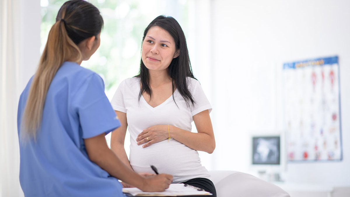 Healthcare provider talks with pregnant patient A healthcare provider talks with a pregnant patient