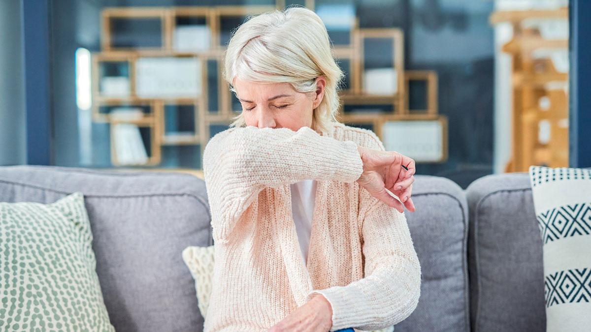 — title missing — Woman feeling ill on the sofa at home.