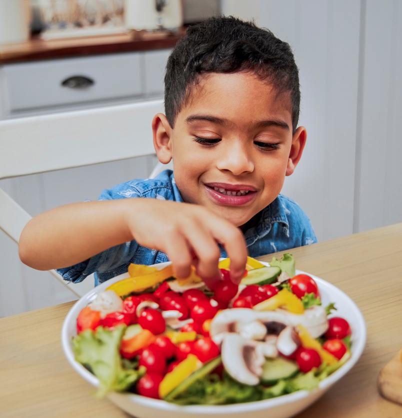 Shot of a little boy eating vegetables Little boy eating a salad