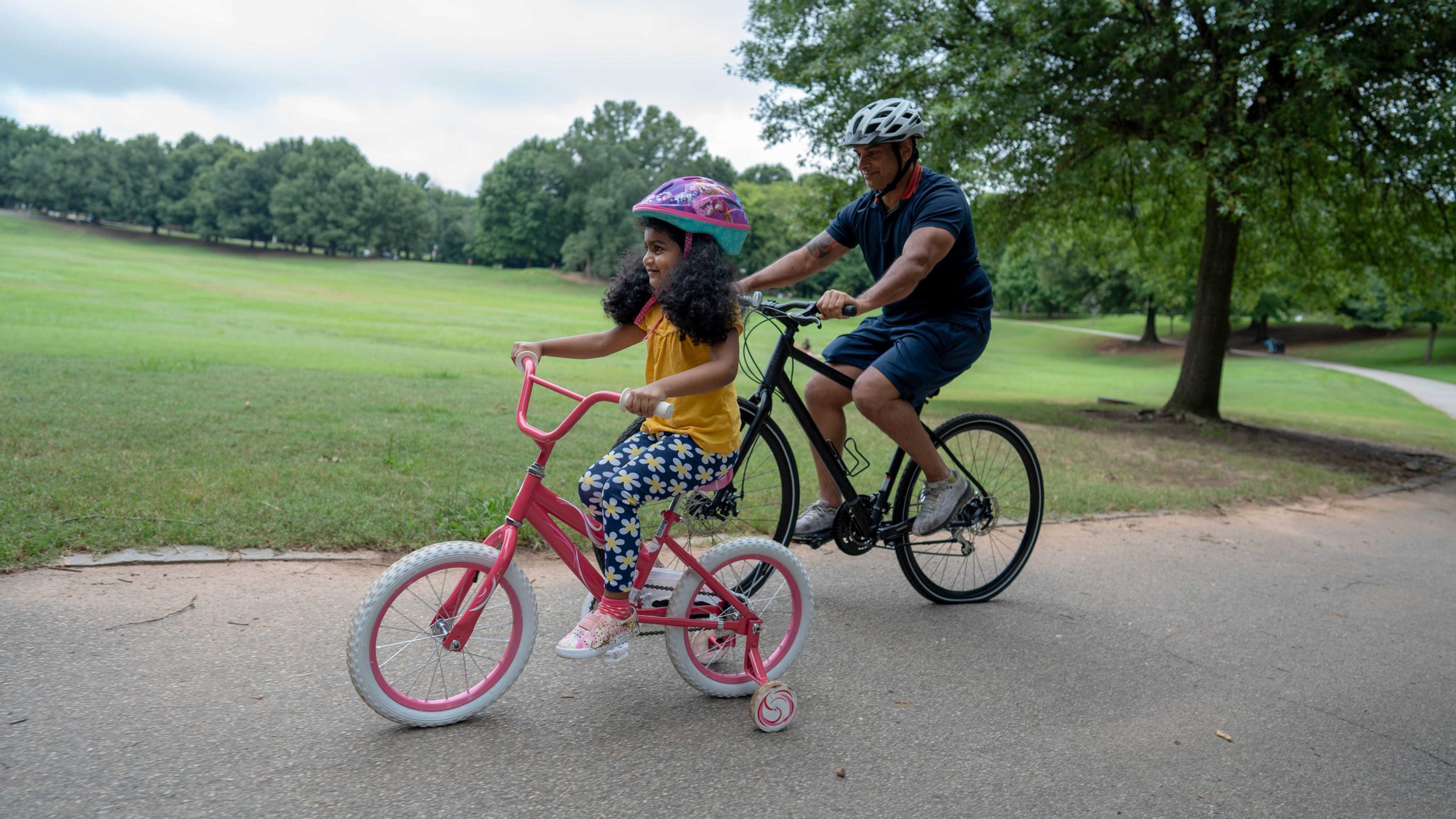 Father_Daughter_biking A father and daughter riding bikes in the park.