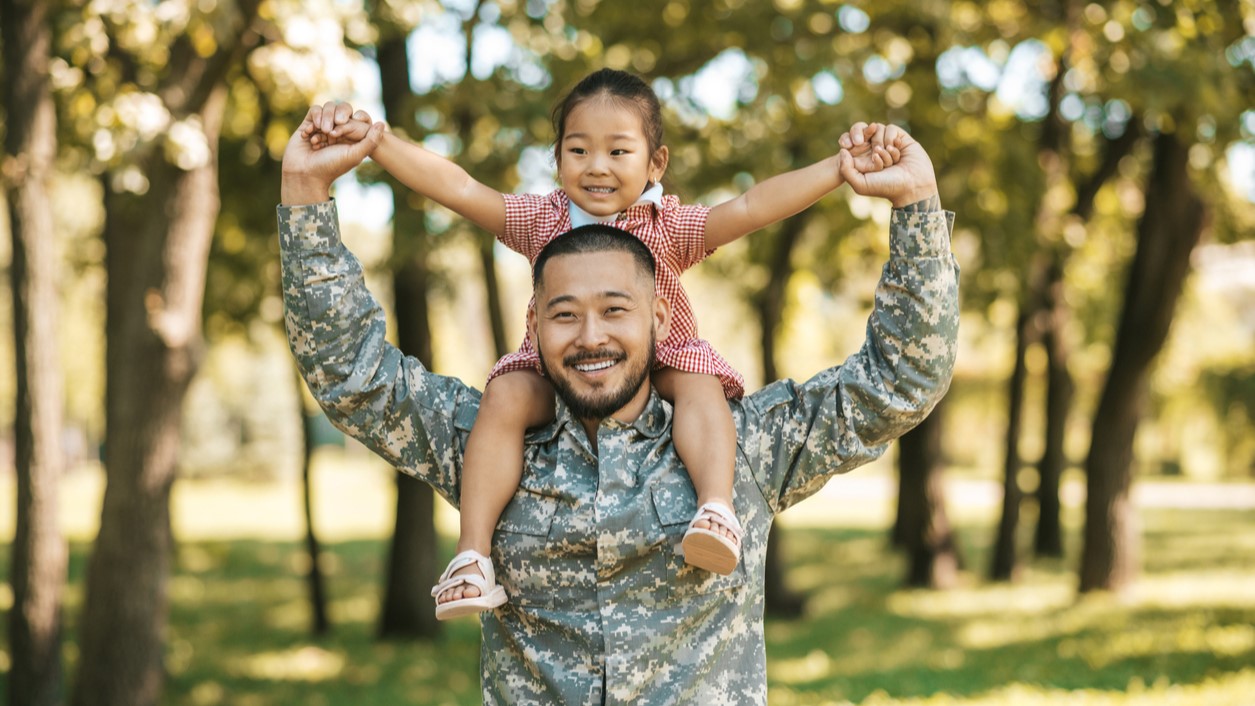 — title missing — Man in military uniform with his daughter on his shoulders