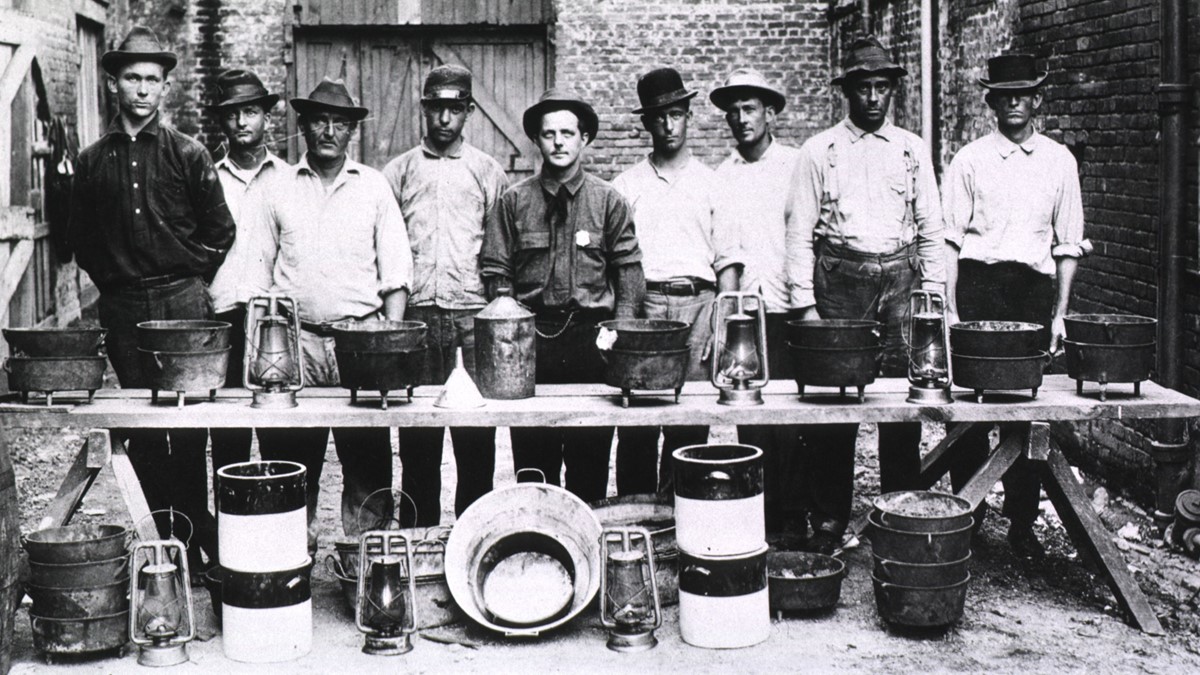 RatCatchers.jpg Rat Catchers in New Orleans; Group portrait of nine men standing behind a makeshift table