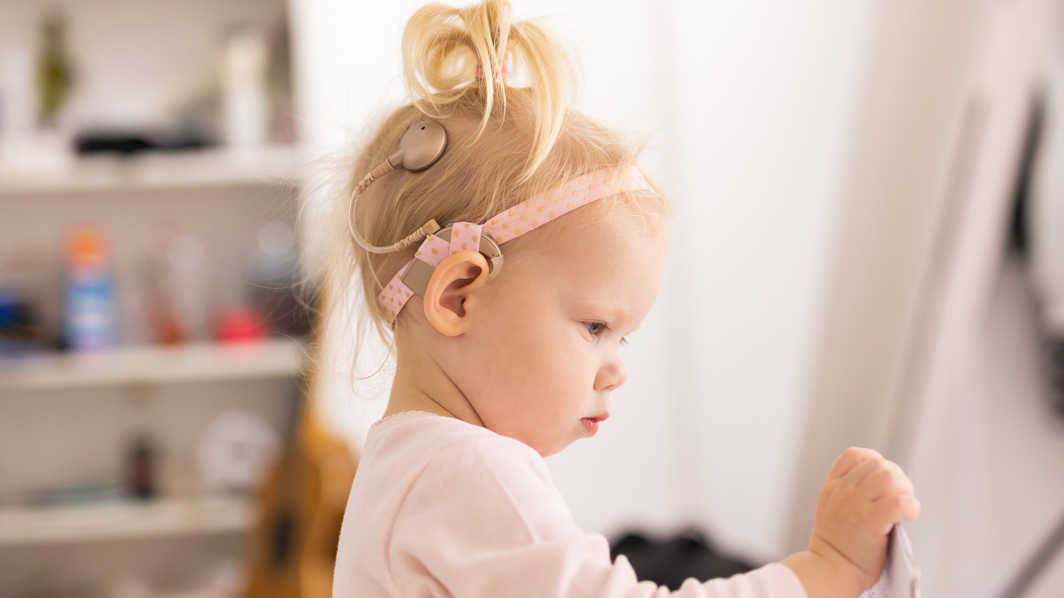 cochlear implant baby Young girl with a cochlear implant wearing a headband.