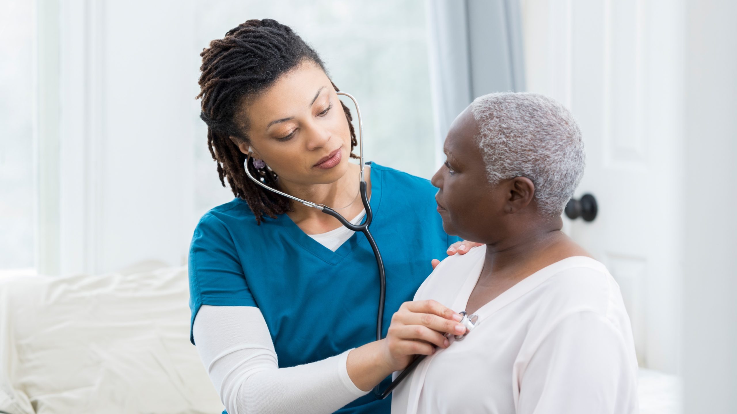 Patient having lungs checked Healthcare provider is using stethoscope to check patient.