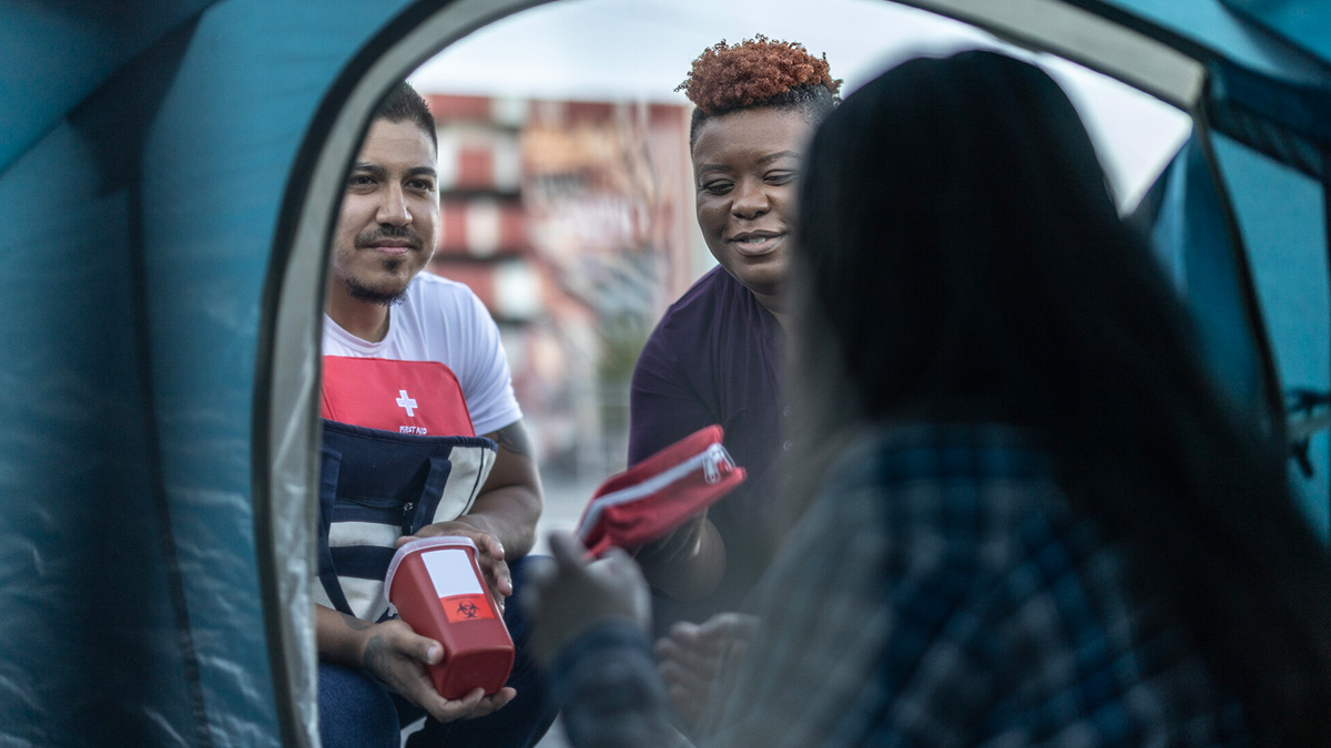 Aid workers help unhoused person Aid workers help an unhoused person.