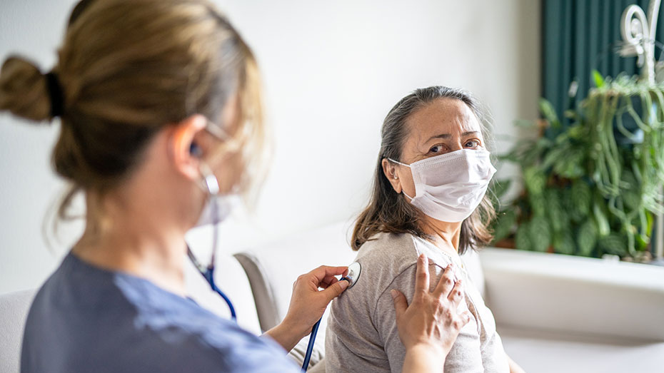 Healthcare worker listens to patient's lungs A healthcare worker listens to a patient's lungs.