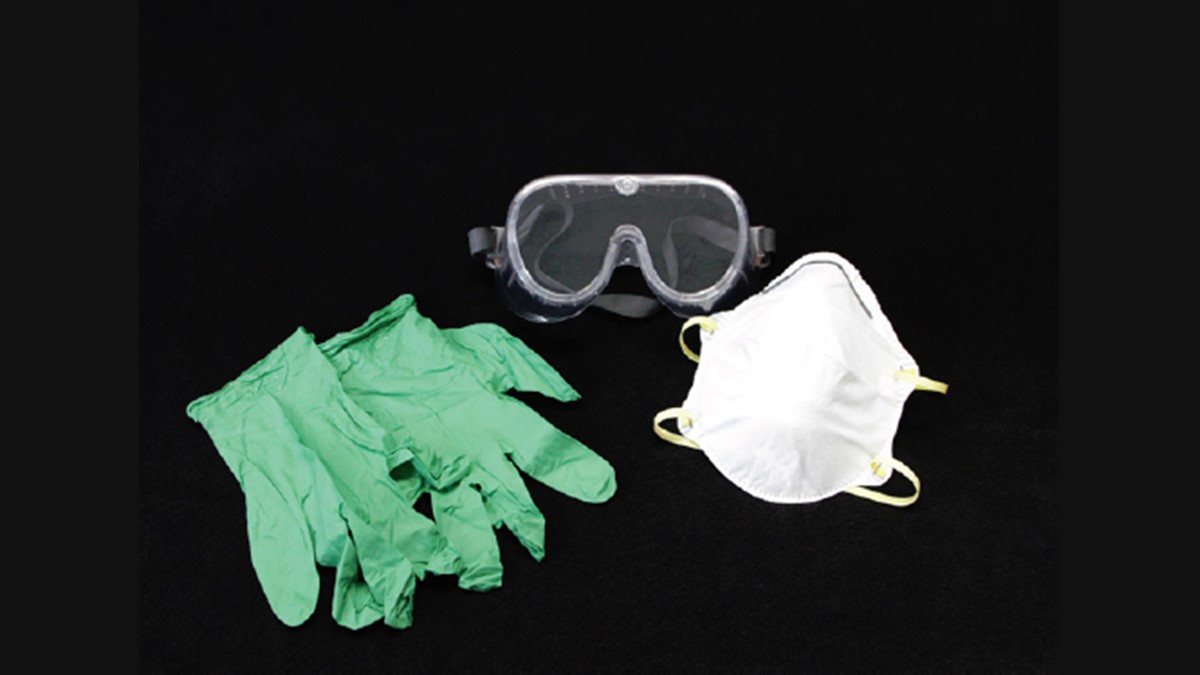 safety-gear A pair of safety goggles, a dust mask, and a pair of rubber gloves on a black background
