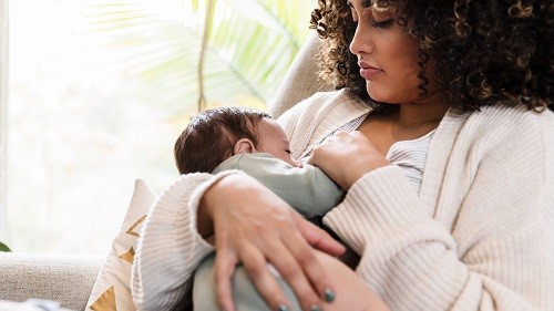 mom breastfeeding Mother watches as baby breastfeeds