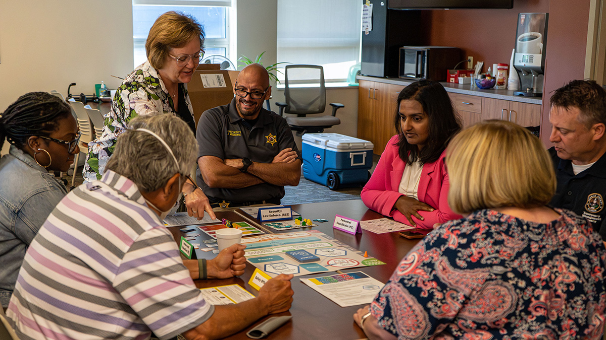 Group of professionals playing TEST Group of people around table playing TEST
