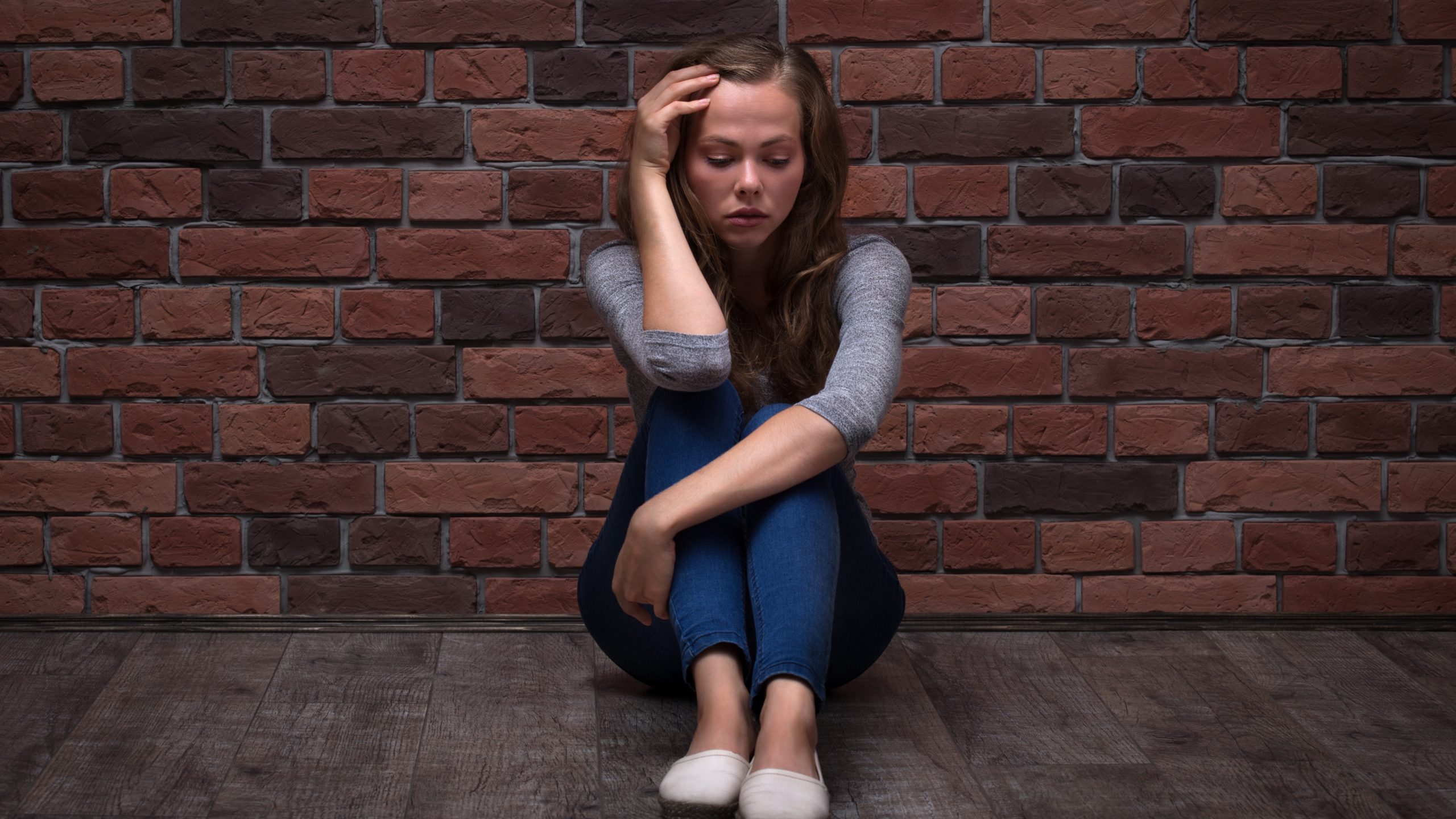 Depressed Teenager Girl Sitting Depressed Teenager Girl Sitting against a brick wall