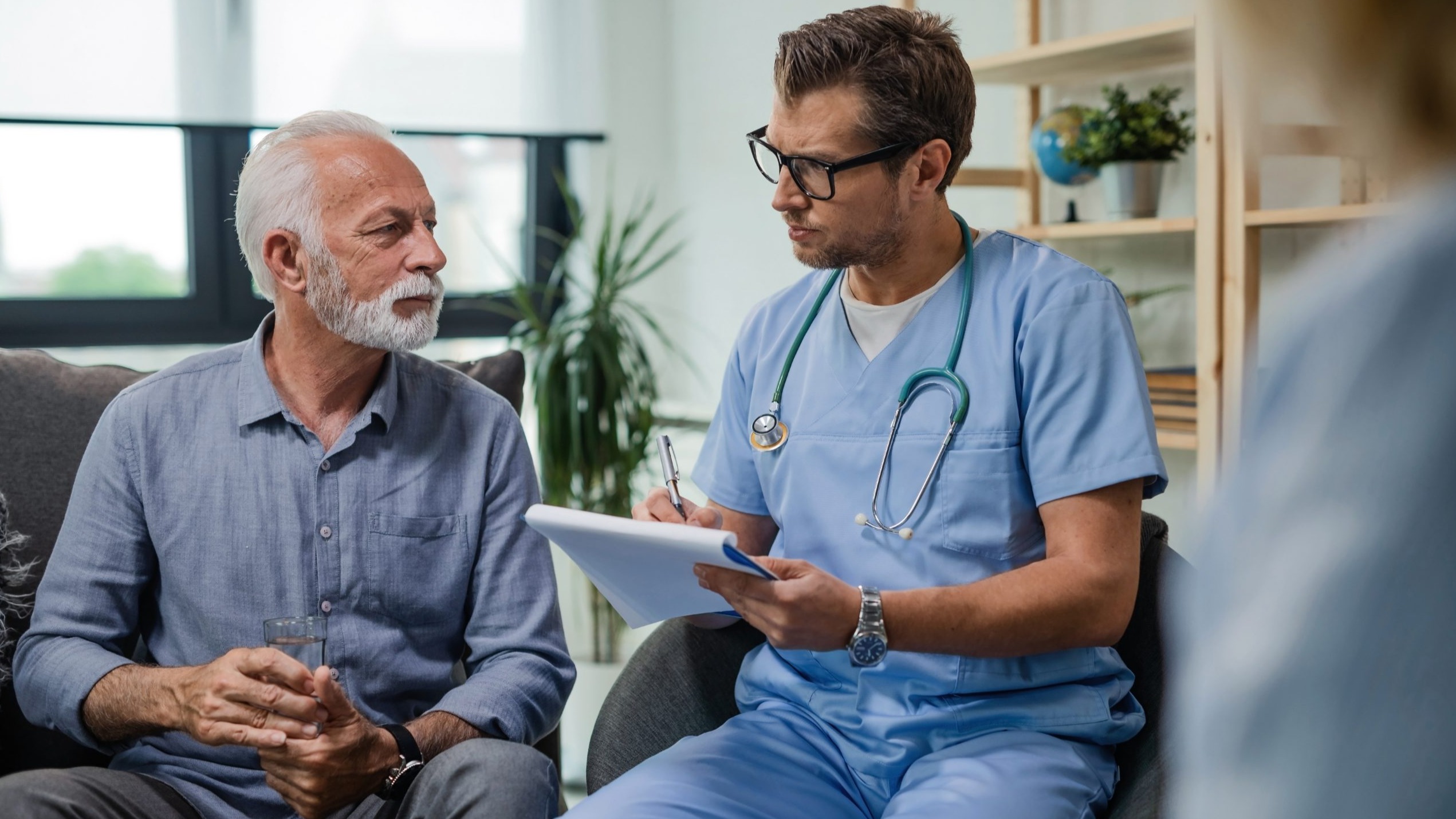 General-Practitioner-Taking-Notes-Senior-Patient-cdcwp1740509599155-16-9 Doctor taking notes with older male patient