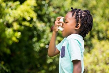 — title missing — A child uses an asthma inhaler.