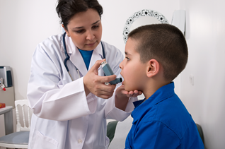 Asthma_Tab2_3.png A school nurse helping a student use an inhaler.