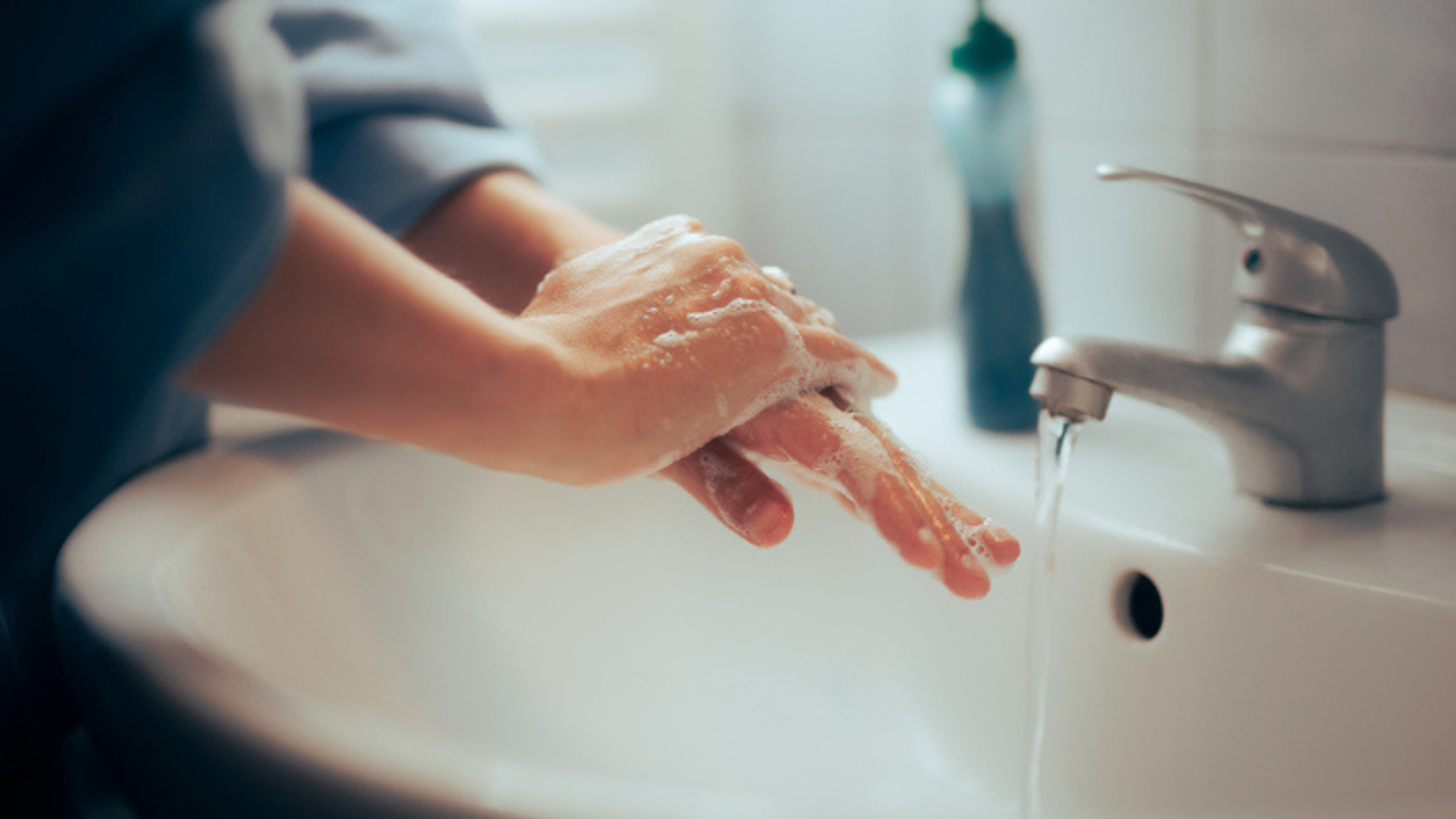 Woman washing hands in bathroom sink