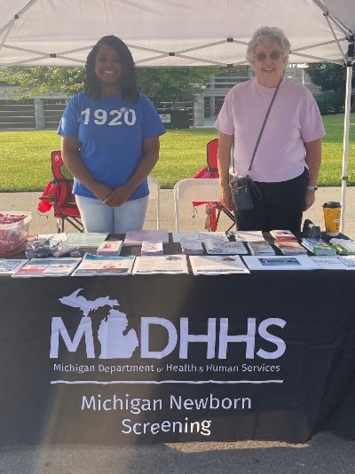 MDHHS at SCDAA walk Two people stand behind a MDHHS table with newborn screening resources
