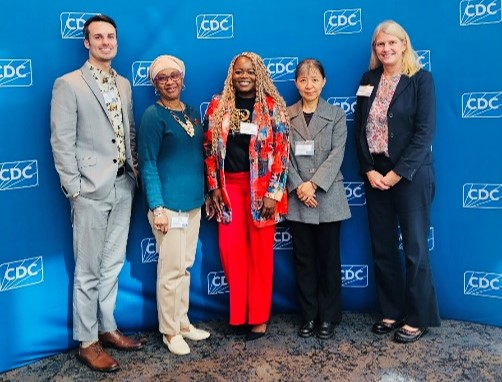 GA SCDC at SCDC RSV Five persons stand together in front of a CDC logo backdrop