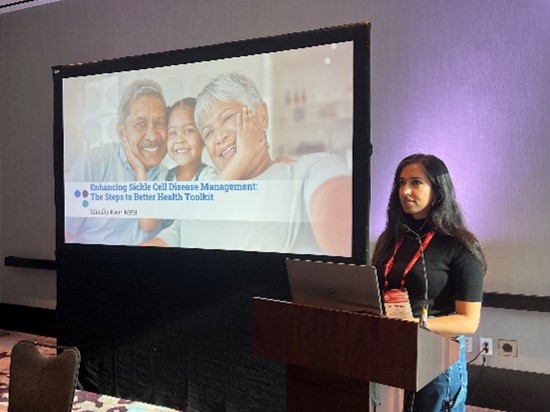 Mandip Kaur at SCDAA A person stands behind a podium presenting a slideshow
