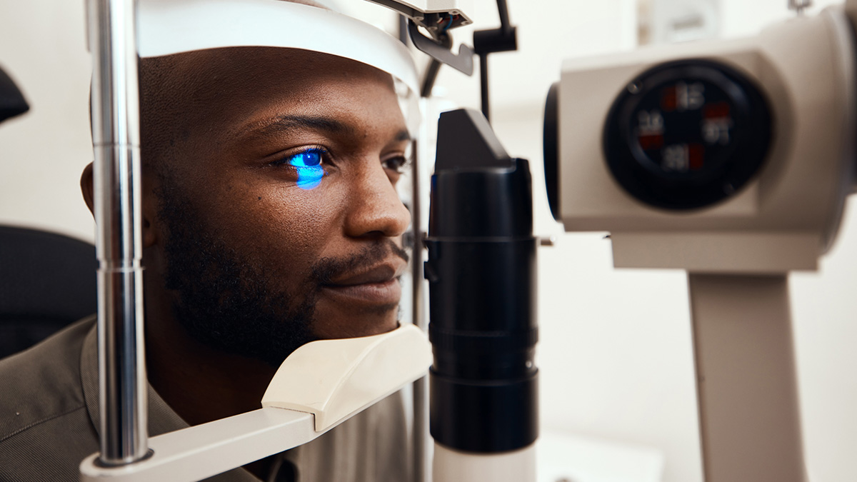 — title missing — Man with his head in an eye-scanning device.